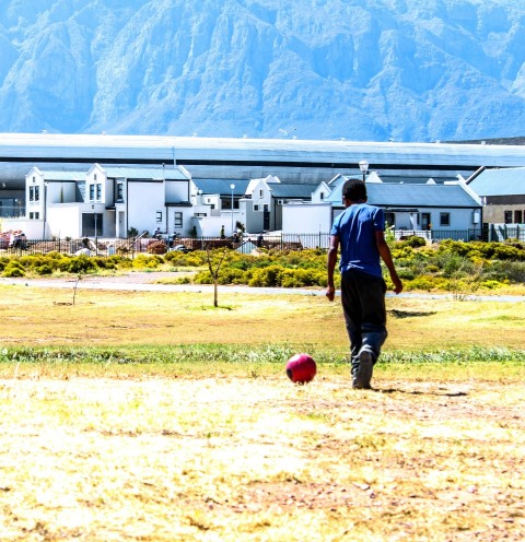 man in black jacket and black pants holding red ball