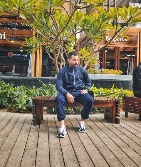 a man sitting on a bench in front of a tree