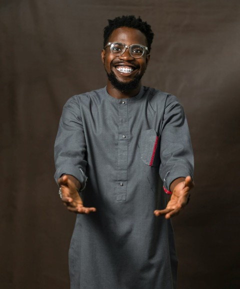 a man in a black and grey outfit with his hands out