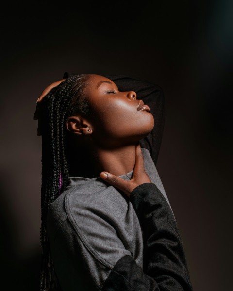 a woman with braids and a black jacket