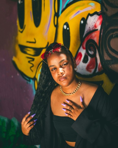 a woman standing in front of a graffiti wall