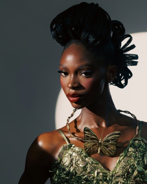 a woman in a green dress with a bow on her neck