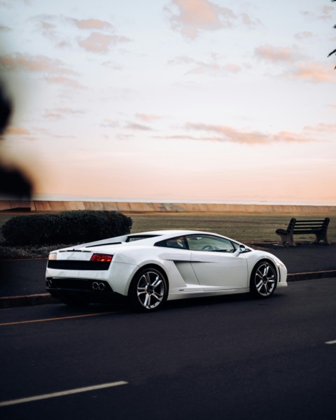 a white sports car driving down a street