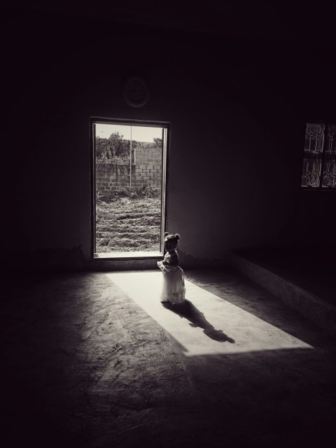 a little girl sitting on the floor in front of a window