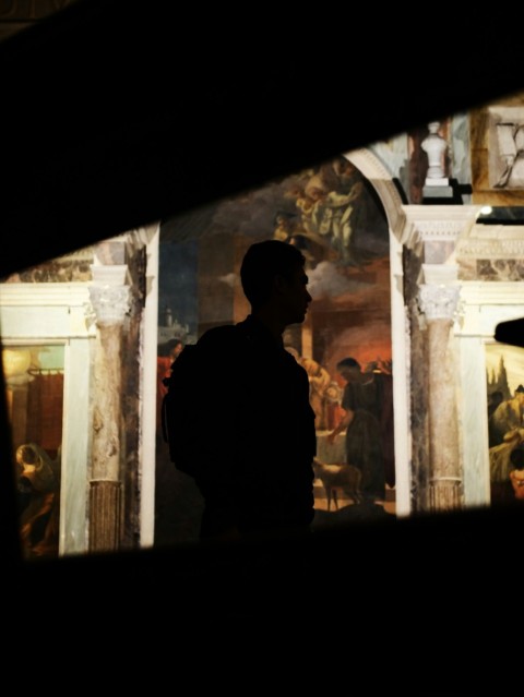 a man standing in front of a painting in a museum