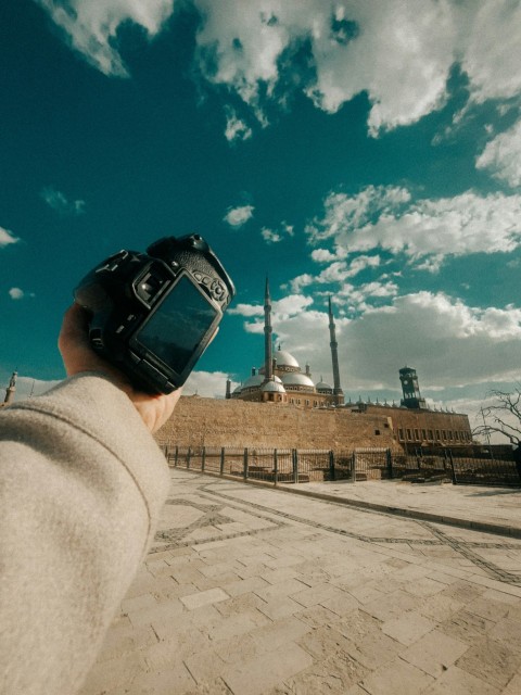 a person holding a cell phone up to the sky