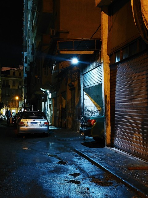 a car parked on the side of a street at night