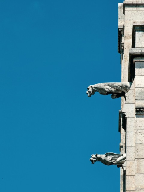 a tall building with statues on the side of it