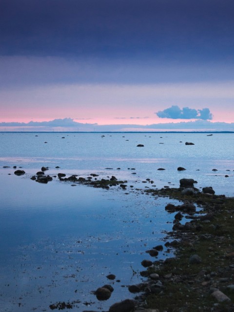 rocks on water during sunset