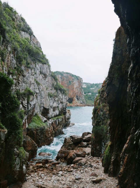 a river flowing through a rocky canyon next to a cliff