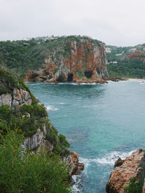 a large body of water surrounded by a lush green hillside