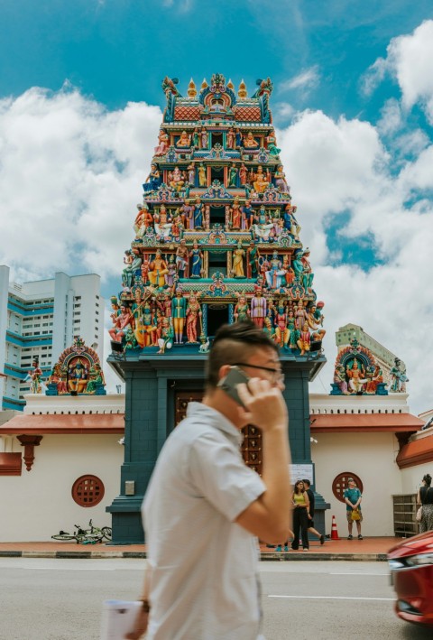 a man walking down a street while talking on a cell phone