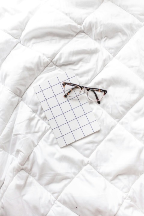 brown framed eyeglasses on white textile