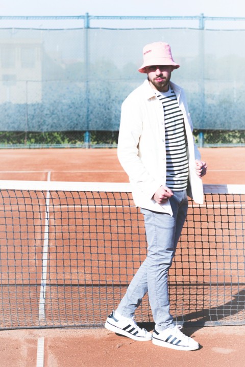 a person in a pink hat standing on a tennis court