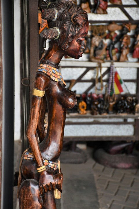 a wooden statue of a woman in a shop