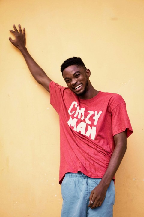 man in red crew neck t shirt and blue denim jeans