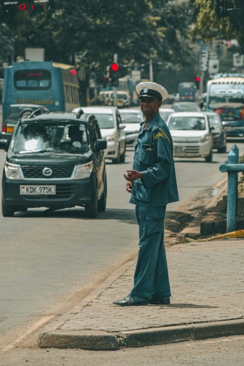 a man in uniform standing on the side of a road