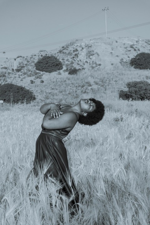 woman in black spaghetti strap dress standing on grass field o