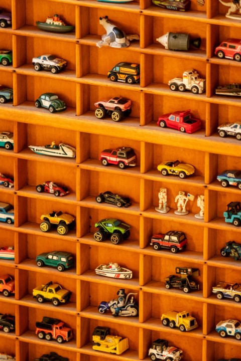 a wooden shelf filled with lots of toy cars