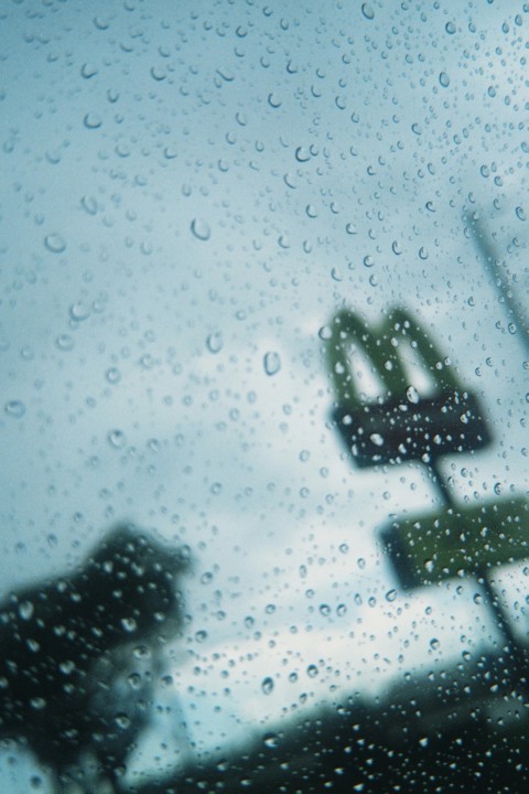 a blurry picture of a street sign in the rain