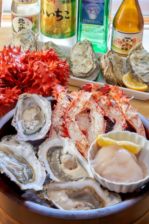 a bowl of oysters and a bottle of alcohol