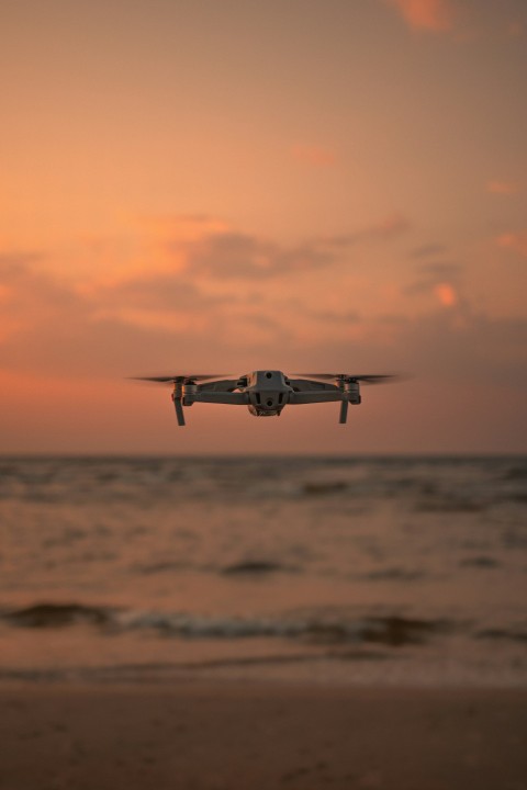 black and white drone flying over the sea during sunset HxH5fGyQ