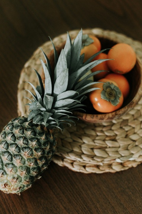 brown and green pineapple fruit on brown woven basket