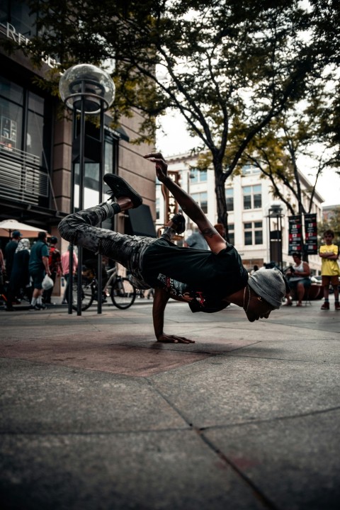 man in black t shirt and blue denim jeans jumping on street during daytime