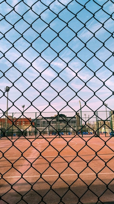 a tennis court through a chain link fence