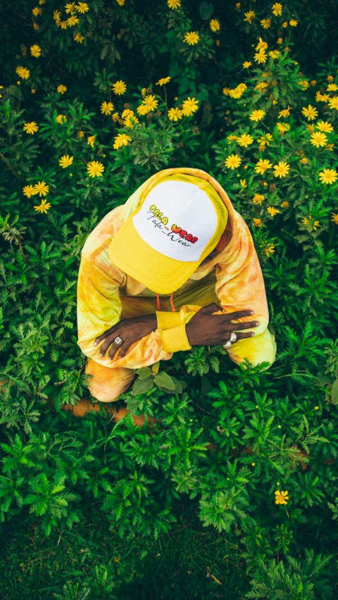 a person kneeling in a field of yellow flowers