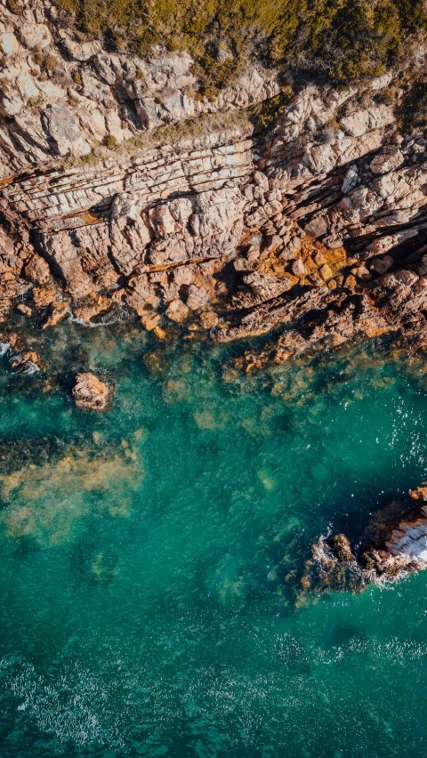 brown rock formation on body of water during daytime