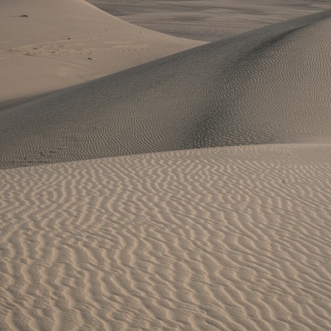a person riding a snowboard on top of a sandy hill