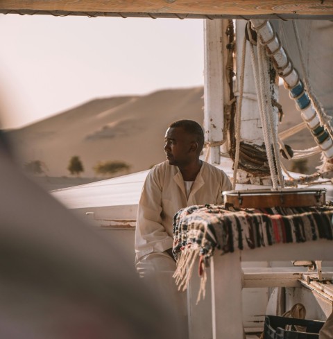 a man sitting on the deck of a boat